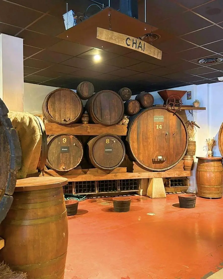 Le chai de la Cidrerie Berri : grands fûts de chêne sous le panneau « Chai »
